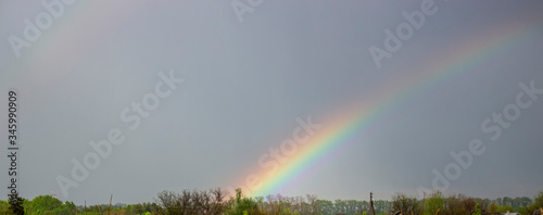Rainbow after heavy rain, downpour in the countryside.