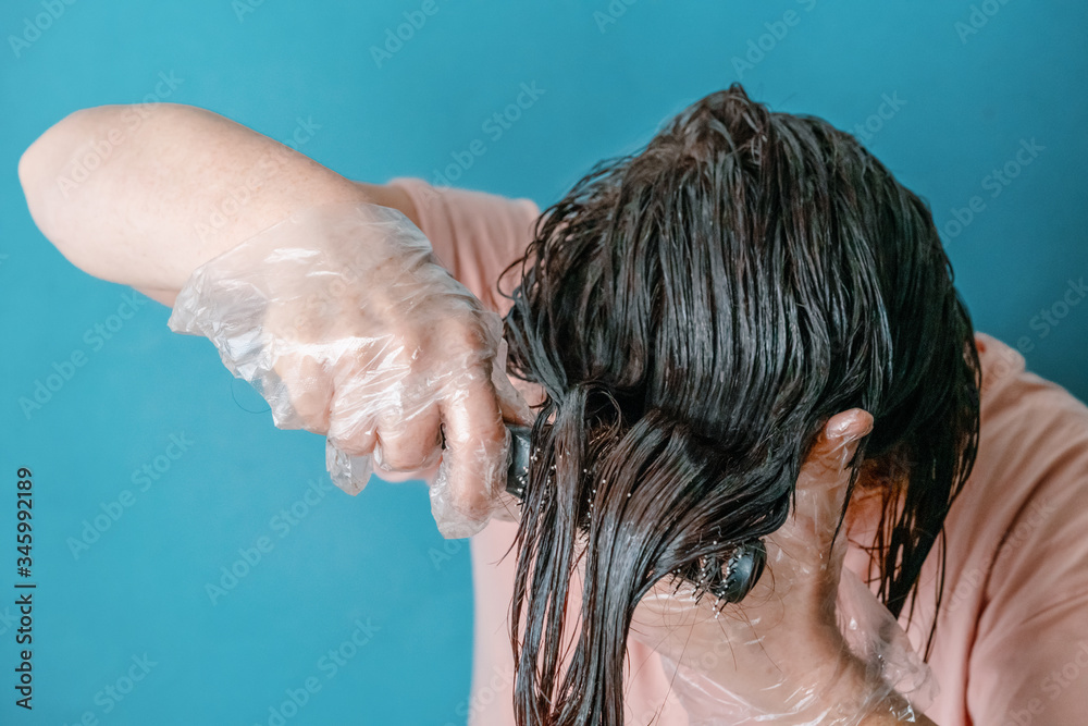Naklejka premium gloved woman combing dyed hair
