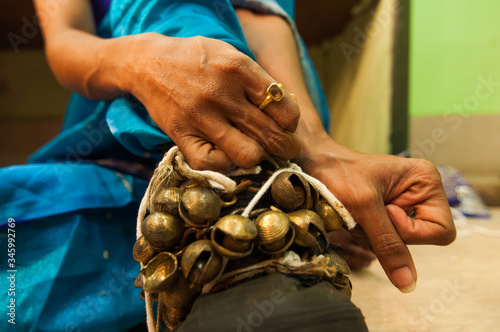 A Lavani dancer tying her Ghungroos on her feet just before a dance show