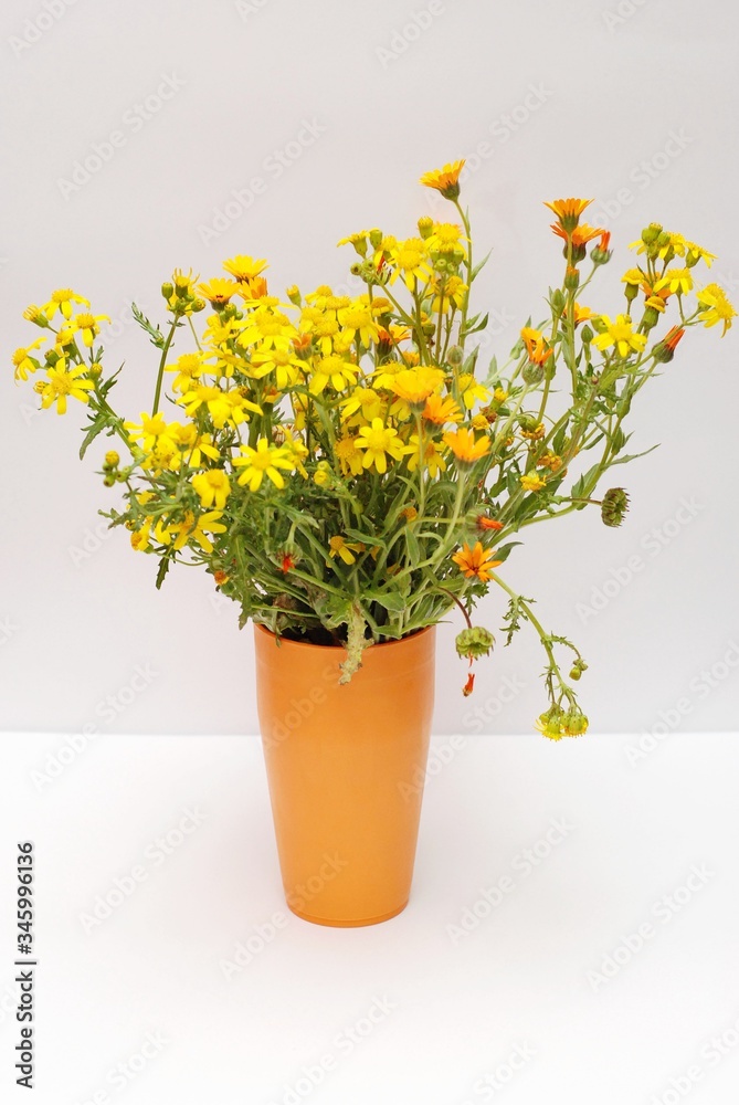 Wildflowers in a vase. Yellow and orange flowers