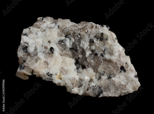 Granite Rock sample isolated on black background. Mineral of volcanic origin