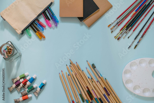 Stationery and art materials on a blue background. Flat lat.