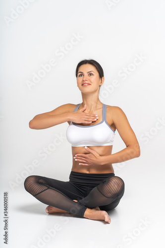 a woman holds one hand on her chest and the other on her stomach. isolated on white background