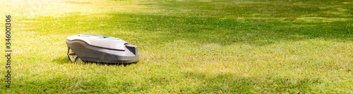 New modern robotic lawnmower on the grass. Gardener equipment. 
