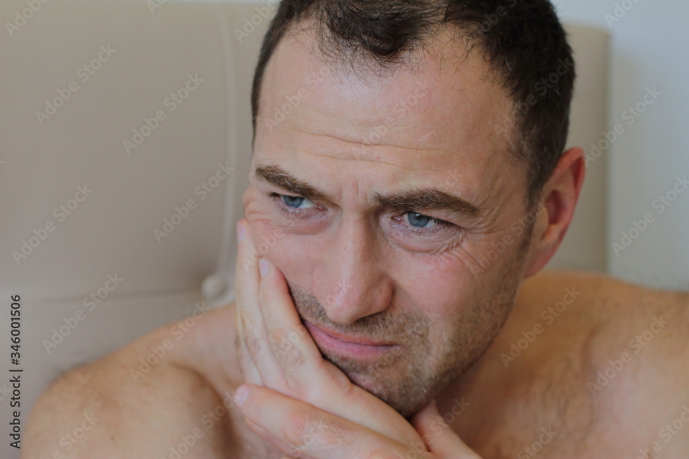 Naklejka premium handsome middle age man is touching his cheek by his hand, he has a pain of teeth, toothache