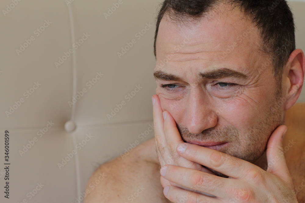 handsome middle age man is touching his cheek by his hand, he has a pain of teeth, toothache handsome middle age man is touching his cheek by his hand, he has a pain of teeth, toothache