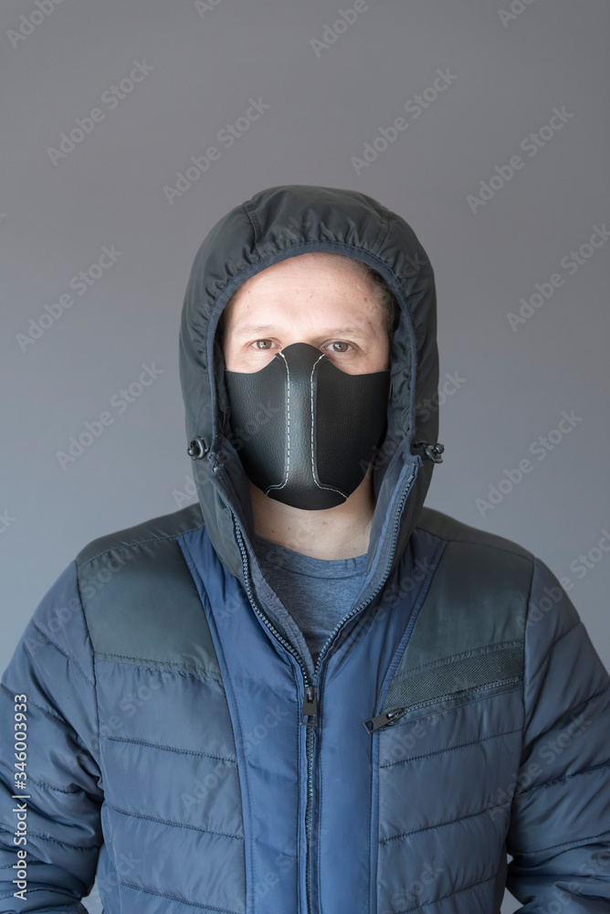 Front portrait of a young man wearing a homemade synthetic leather face mask Front portrait of a young man wearing a homemade synthetic leather face mask