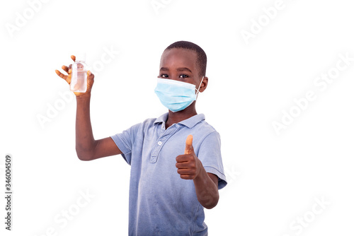 little boy with a medical mask holding an antibacterial gel.