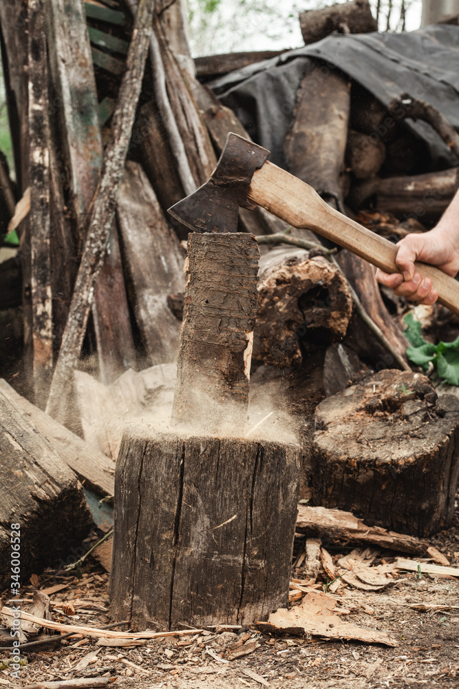 Strong man chopping an ax with a log. Work in the village. Strong man chopping an ax with a log. Work in the village.