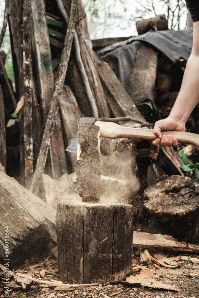 Strong man chopping an ax with a log. Work in the village. Strong man chopping an ax with a log. Work in the village.