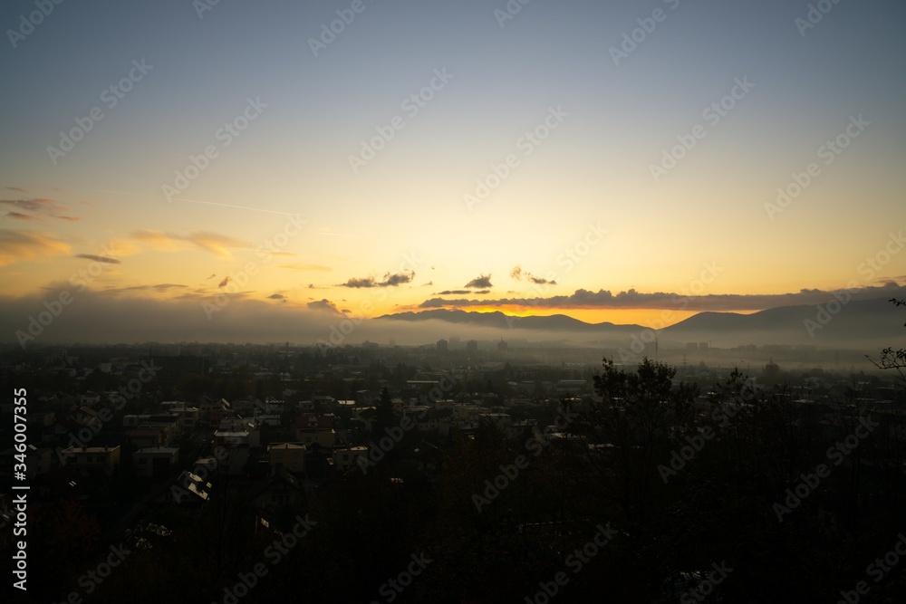 Sunrise and sunset, beautiful clouds over the meadow, hills and buildings in the town. Slovakia Sunrise and sunset, beautiful clouds over the meadow, hills and buildings in the town. Slovakia