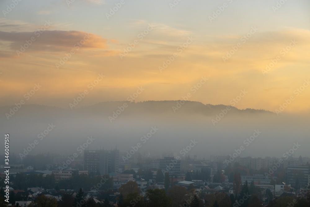 Sunrise and sunset, beautiful clouds over the meadow, hills and buildings in the town. Slovakia Sunrise and sunset, beautiful clouds over the meadow, hills and buildings in the town. Slovakia