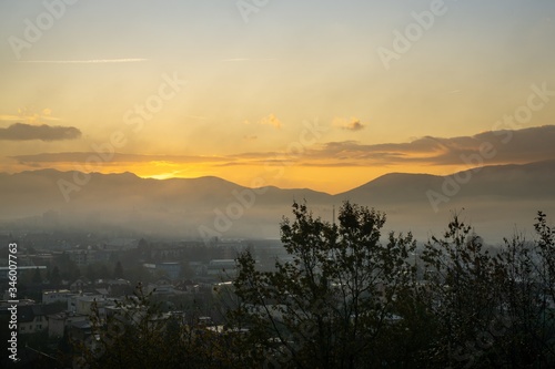 Sunrise and sunset, beautiful clouds over the meadow, hills and buildings in the town. Slovakia