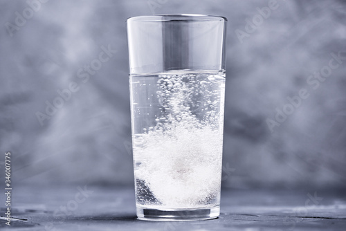 Effervescent vitamin C tablet bubbles in glass of water