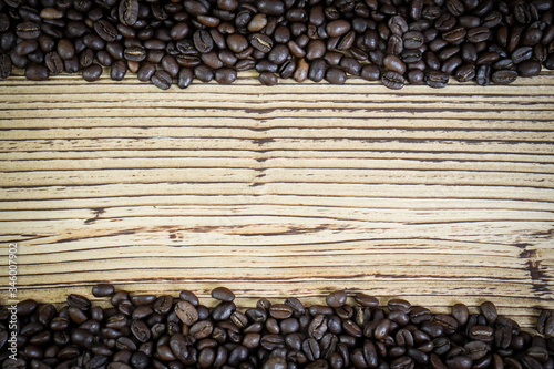 Fresh coffee beans on wooden table background. © Nataly