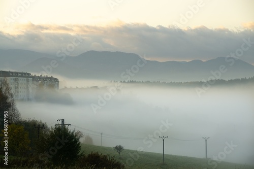 Fototapeta Naklejka Na Ścianę i Meble -  Sunrise and sunset, beautiful clouds over the meadow, hills and buildings in the town. Slovakia