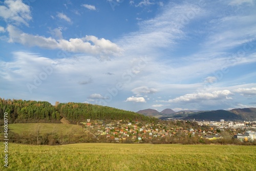 Sunrise and sunset, beautiful clouds over the meadow, hills and buildings in the town. Slovakia