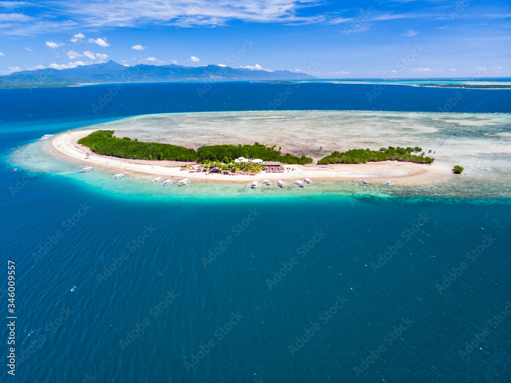 Fototapeta premium Aerial view of tropical island surrounded by turquoise water