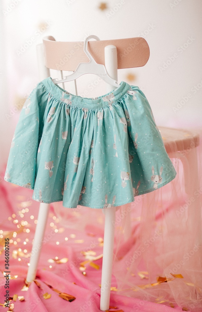Stock Photo - Child skirt on hanger on pink background 