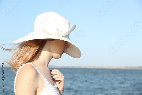 woman in hat on the beach in white hat