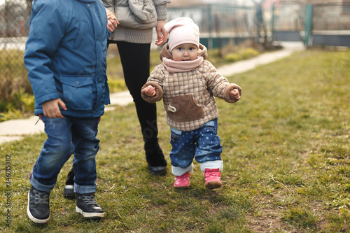 Wallpaper Mural Outdoor spring portrait of little cute toddler girl in brown coat. Healthy happy baby child walking in the park. Torontodigital.ca