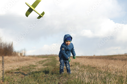 Wallpaper Mural Boy playing with toy glider in field on spring day Torontodigital.ca