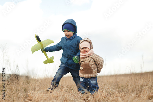 Wallpaper Mural Summer holidays - love romance and people concept. Happy children enjoying summer vacation. Little children with toy airplane in a field at sunset Torontodigital.ca