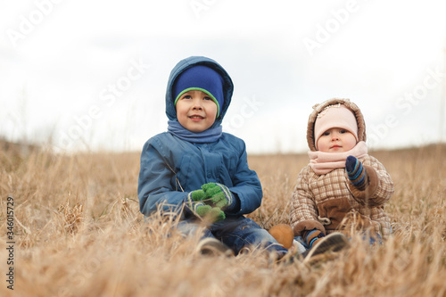 Wallpaper Mural Brother and sister sitting in the dry grass in the spring in the field. Torontodigital.ca