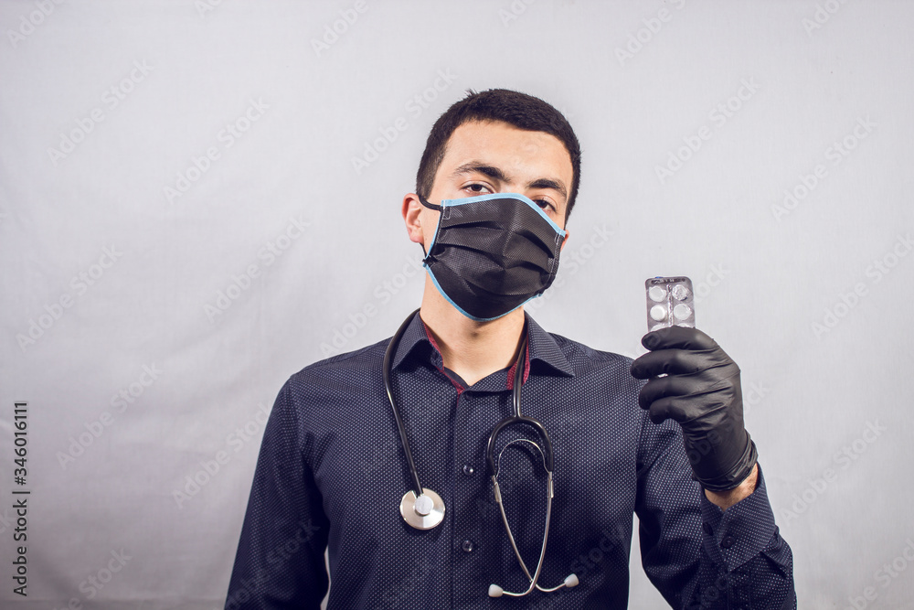 Doctor standing with stethoscope holding pills. Doctor standing with stethoscope holding pills.