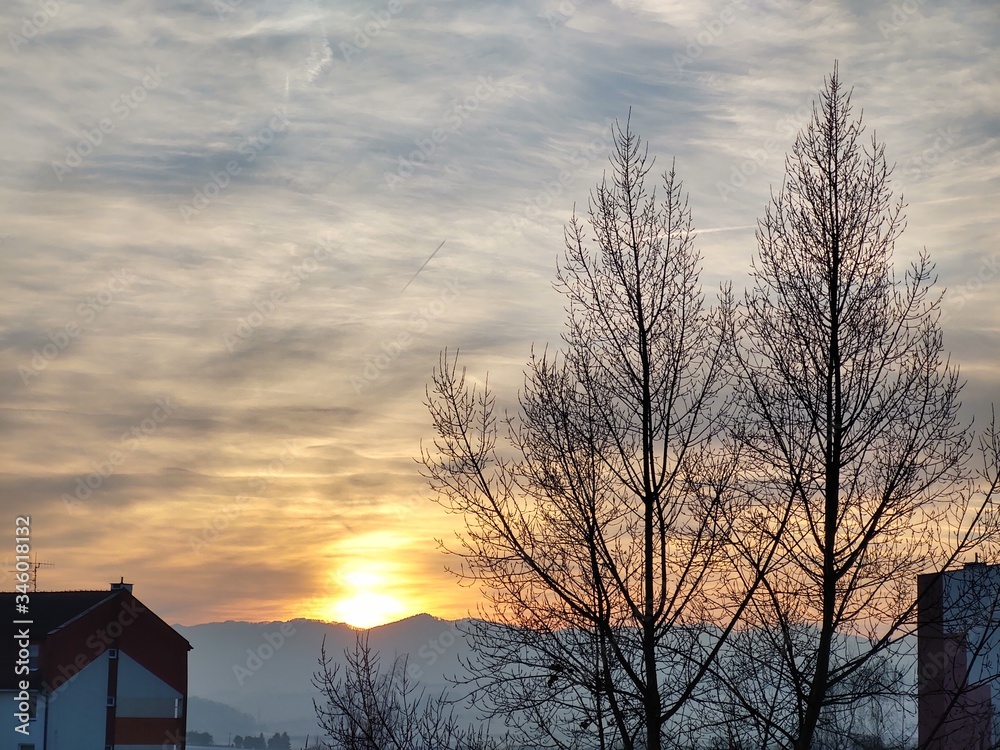 Sunrise and sunset, beautiful clouds over the meadow, hills and buildings in the town. Slovakia Sunrise and sunset, beautiful clouds over the meadow, hills and buildings in the town. Slovakia