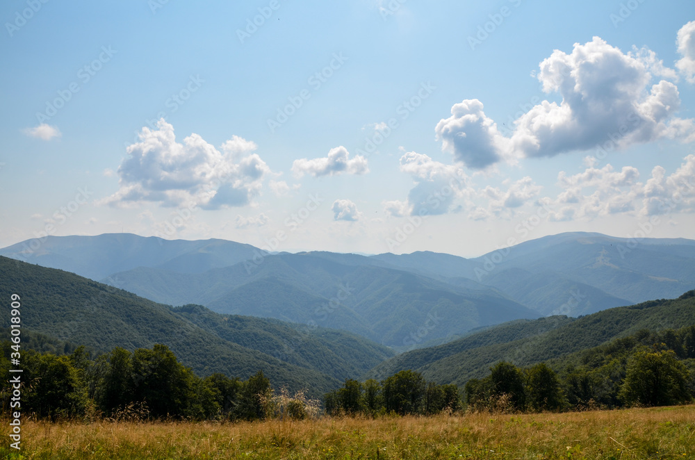 Picturesque summer landscape with forest slopes, mountain ranges and peaks in the Carpathians, Ukraine. Holidays in the mountains.