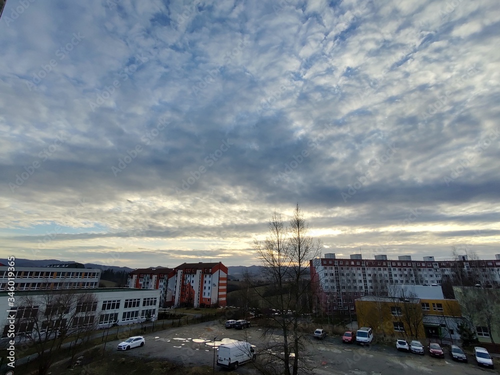 Sunrise and sunset, beautiful clouds over the meadow, hills and buildings in the town. Slovakia Sunrise and sunset, beautiful clouds over the meadow, hills and buildings in the town. Slovakia