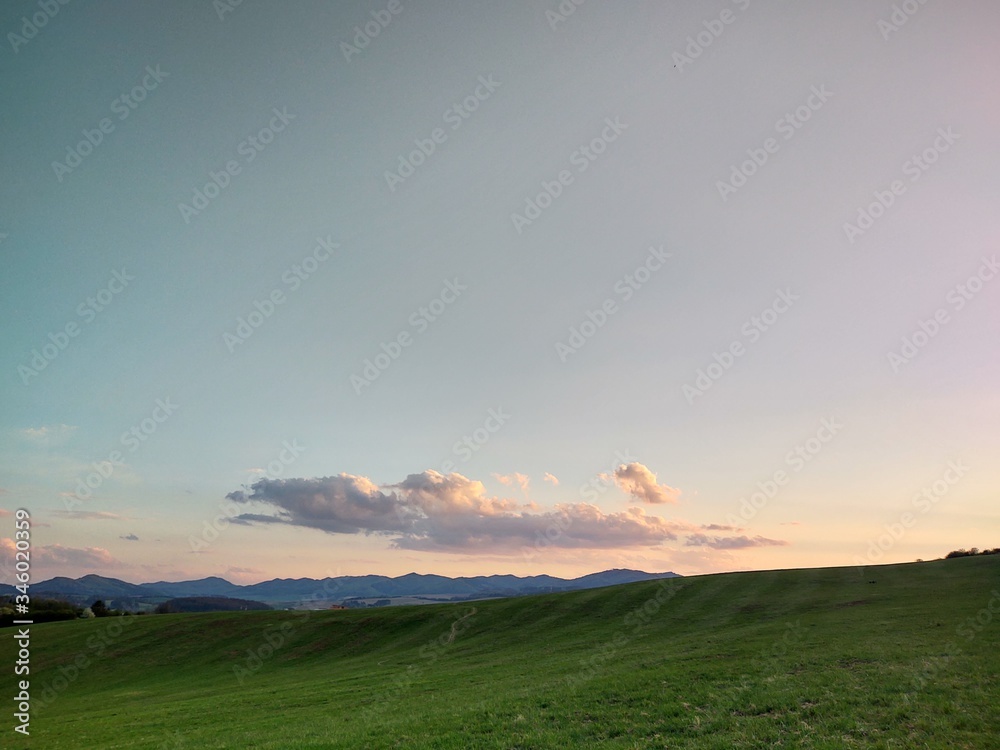 Sunrise and sunset, beautiful clouds over the meadow, hills and buildings in the town. Slovakia Sunrise and sunset, beautiful clouds over the meadow, hills and buildings in the town. Slovakia