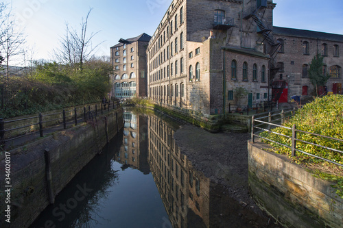 Old converted warehouse reflected on to the river in Ouseburn area of Newcastle Upon Tyne