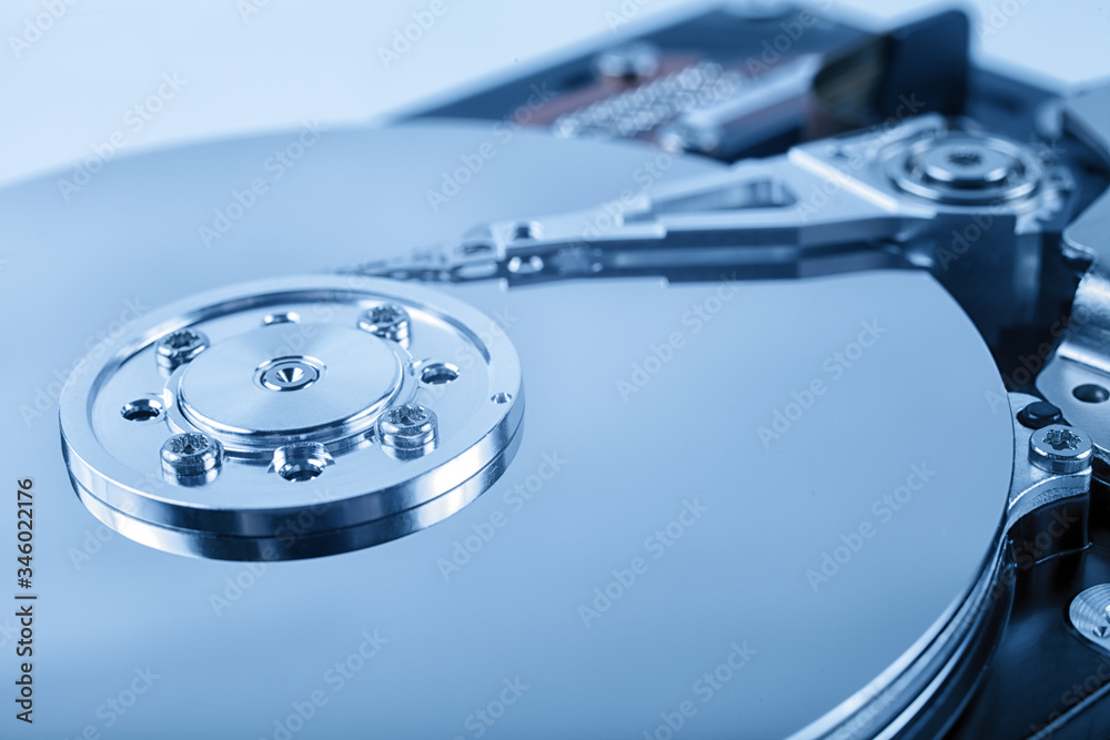Disassembled computer hard drive with mirror disks. Toned blue color. Soft focus. Disassembled computer hard drive with mirror disks. Toned blue color. Soft focus.