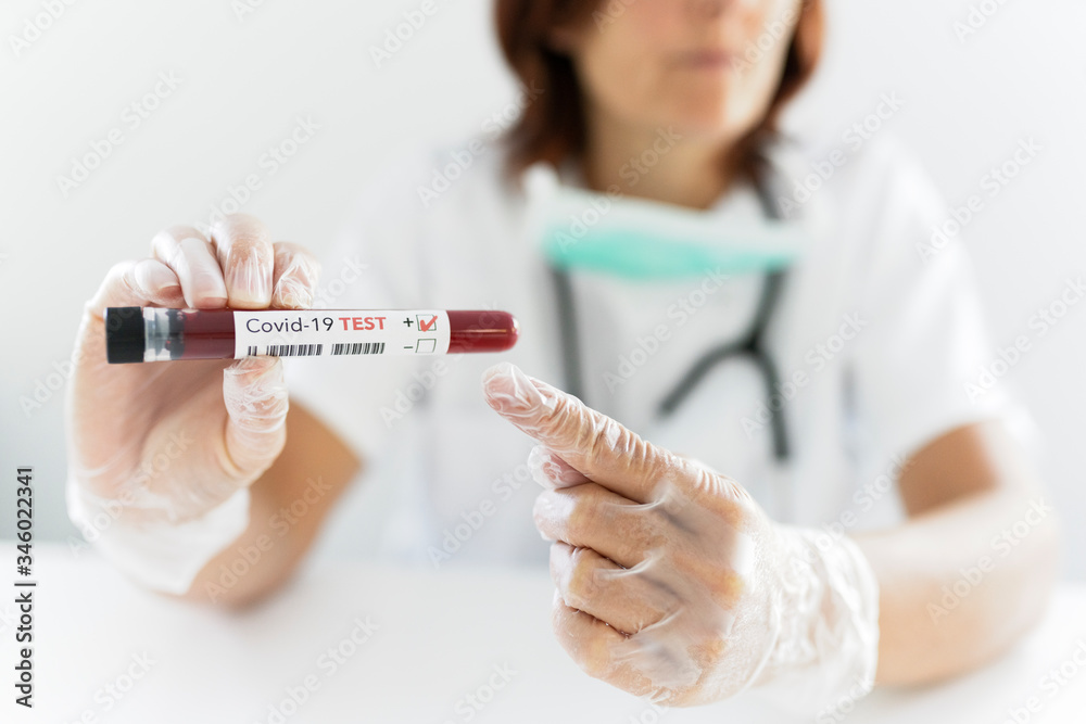 Nurse wearing respirator mask holding a positive blood test result for the new rapidly spreading Coronavirus Nurse wearing respirator mask holding a positive blood test result for the new rapidly spreading Coronavirus