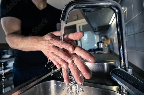 Uomo che si lava le mani in cucina sul lavello