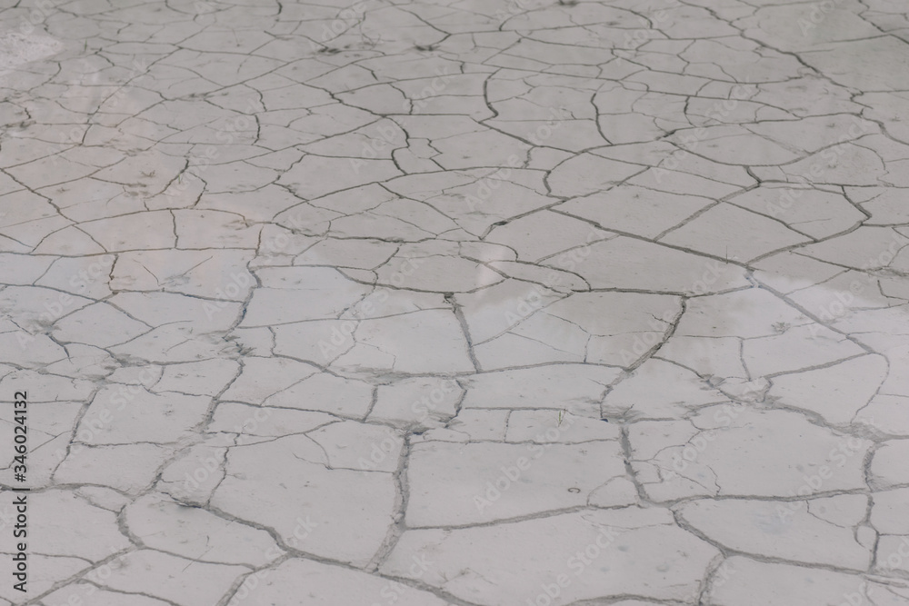old abandoned limestone quarry flooded with water. White earth in cracks, covered with water. Natural background texture old abandoned limestone quarry flooded with water. White earth in cracks, covered with water. Natural background texture