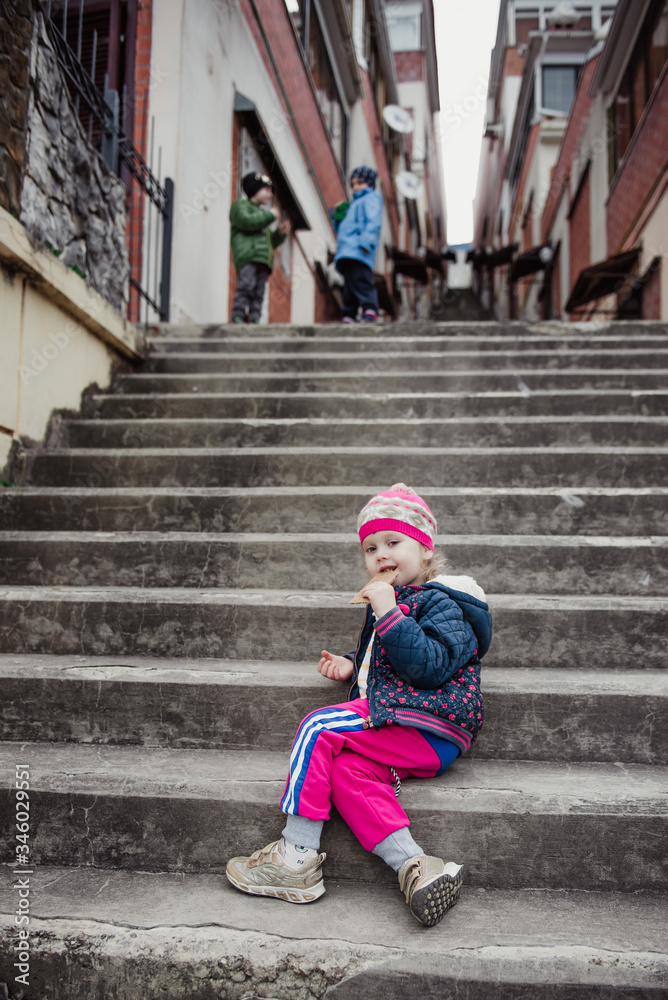 A little girl walks with bread on the street A little girl walks with bread on the street