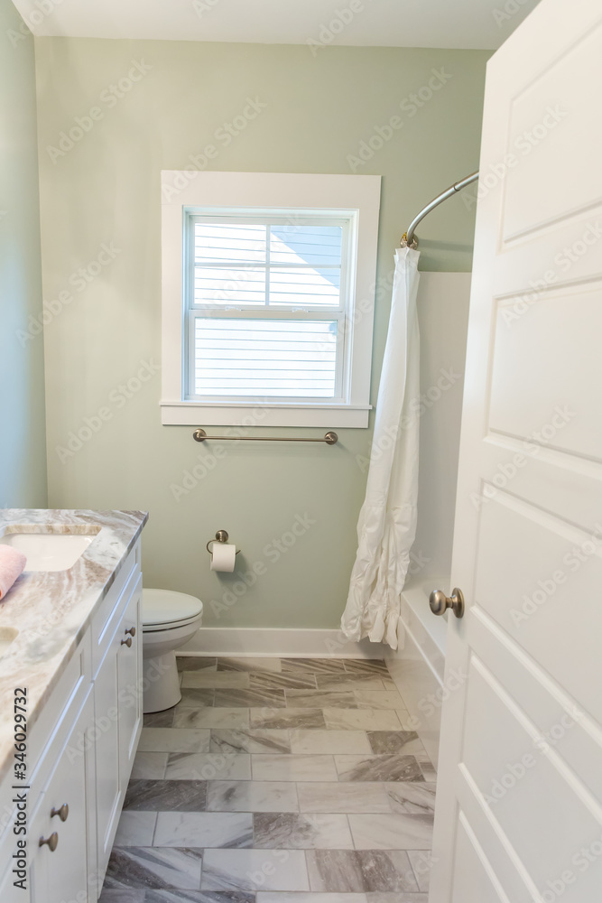 Small green guest bathroom with green walls and a gray and white tiled ...