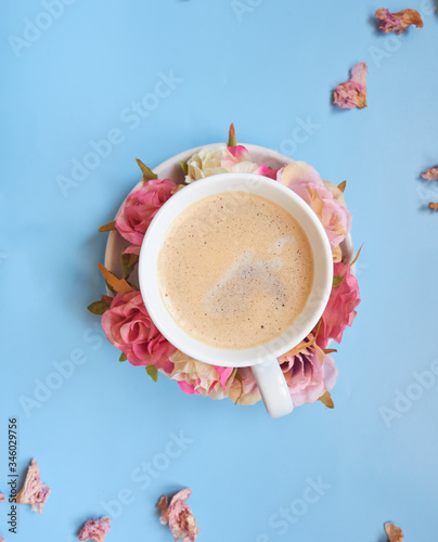 Coffee cup with flower decoration. The background is blue.