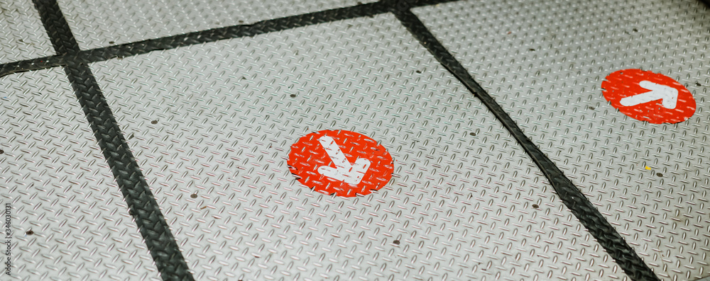 View of footprint sign for stand in lift. Social distancing with COVID-19 coronavirus crisis.Red point sign with text caution social distance, Social distancing in elevator (Lift) in department store.