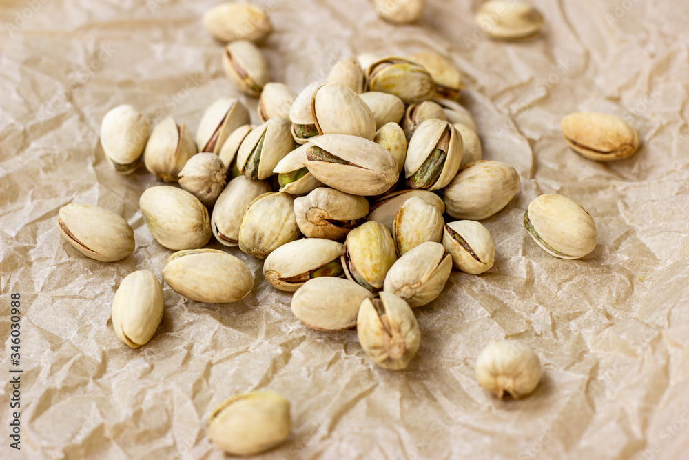 Roasted salted pistachio nuts in nutshell on light background.