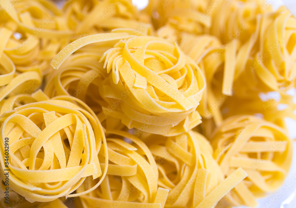 Uncooked fettuccine nest pasta texture background Uncooked fettuccine nest pasta texture background