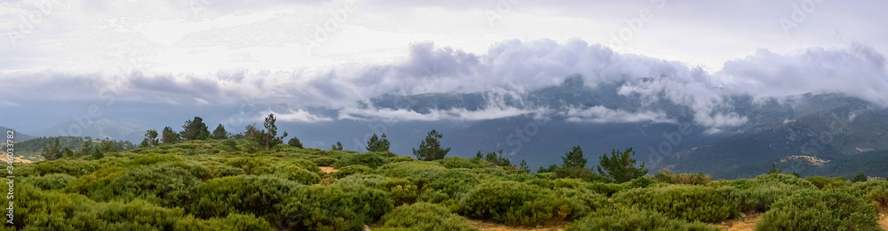 Panoramic image of the views of the Sierra de Guadarrama with its clouds from the top of a mountain peak. Panoramic image of the views of the Sierra de Guadarrama with its clouds from the top of a mountain peak.