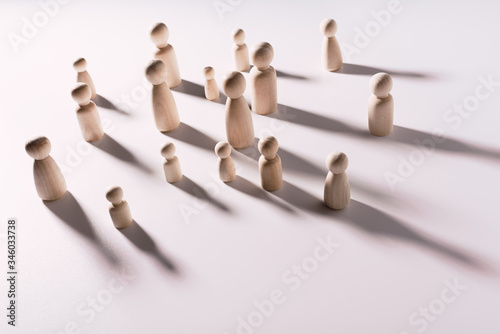 Minimalistic social loneliness concept with wooden figures on white background.