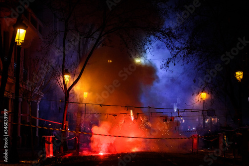 Colorful mascleta full of firecrackers and fireworks with lots of smoke and sparks.