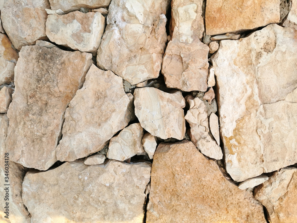 Fototapeta premium Stone wall of large yellow stone for background