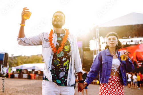 Couple in love drinking beer and having fun at music festival. Beach party  summer holiday  vacation concept. 