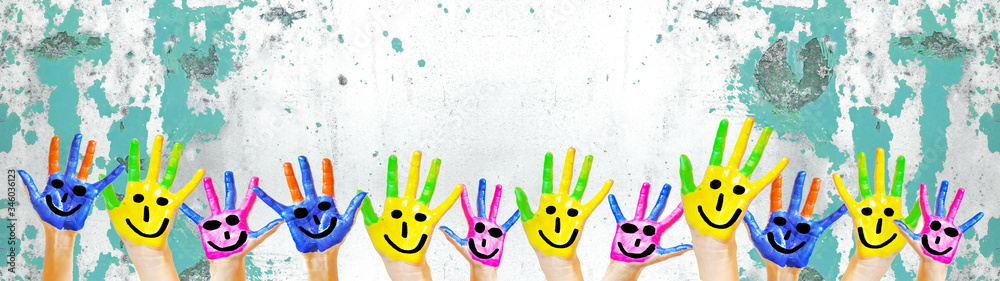 Many brightly painted children's hands with smileys, isolated on white background banner panorama with speckled spotted turquoise paint blobs, with space for text - obrazy, fototapety, plakaty 